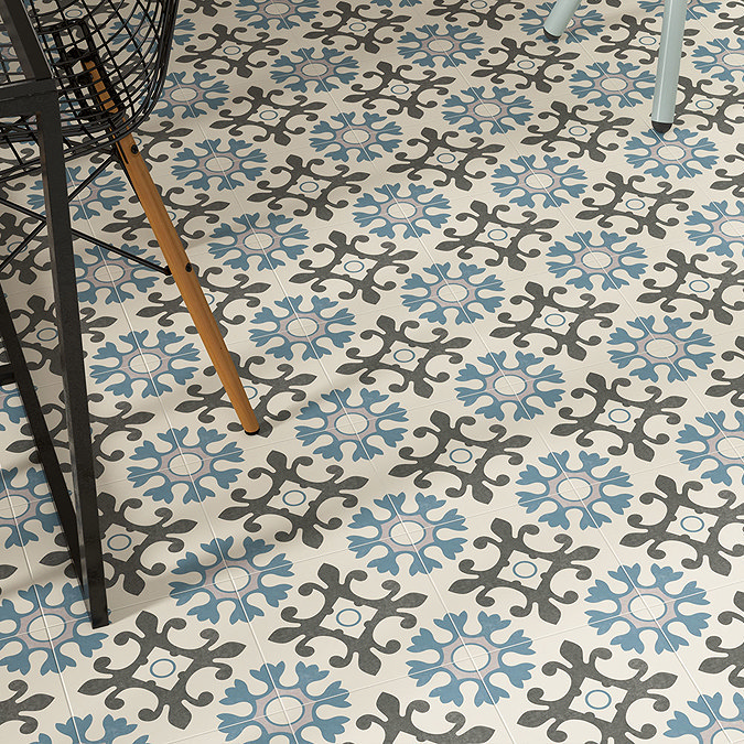 Vintage-inspired blue and grey patterned floor tiles in a contemporary space with modern furniture accents.