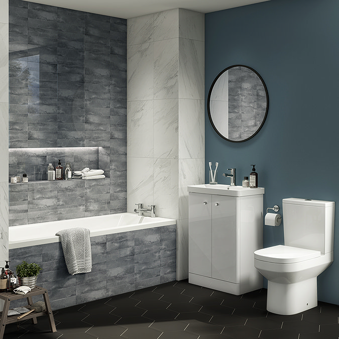 Dark grey stone-effect tiled bath panel seamlessly integrated with matching wall tiles, creating a sleek, built-in look for a modern bathroom.