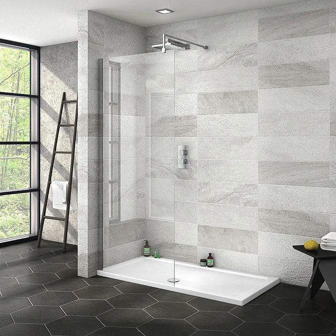 Modern walk-in shower with sleek glass panel, grey stone-effect wall tiles, and hexagonal black floor tiles, creating a minimalist, spa-like bathroom retreat.