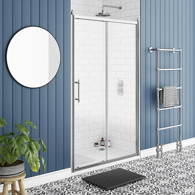 Bathroom with blue panelled walls, glass shower enclosure, and chrome heated towel rail