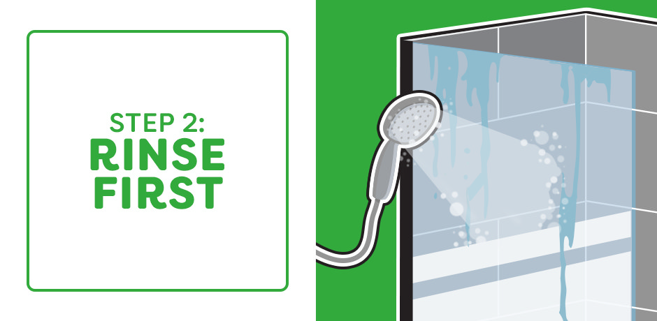 Rinsing shower tiles with handheld shower head before cleaning soap scum