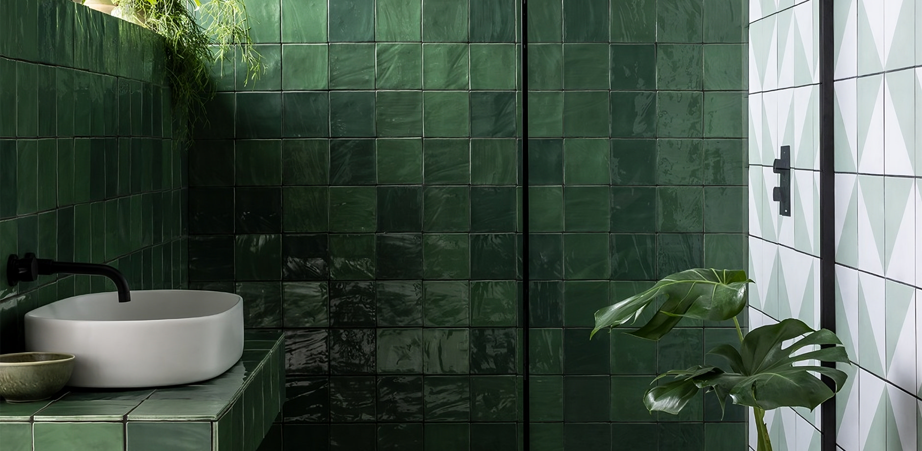 Modern wet room with green tiles, black-framed shower screen, and a seamless, open shower area with floor-level drainage