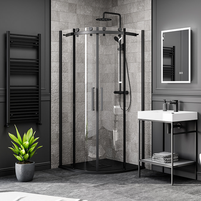 Modern soft industrial bathroom with black accents, featuring a quadrant shower enclosure, matte black towel radiator, and a sleek basin vanity unit.