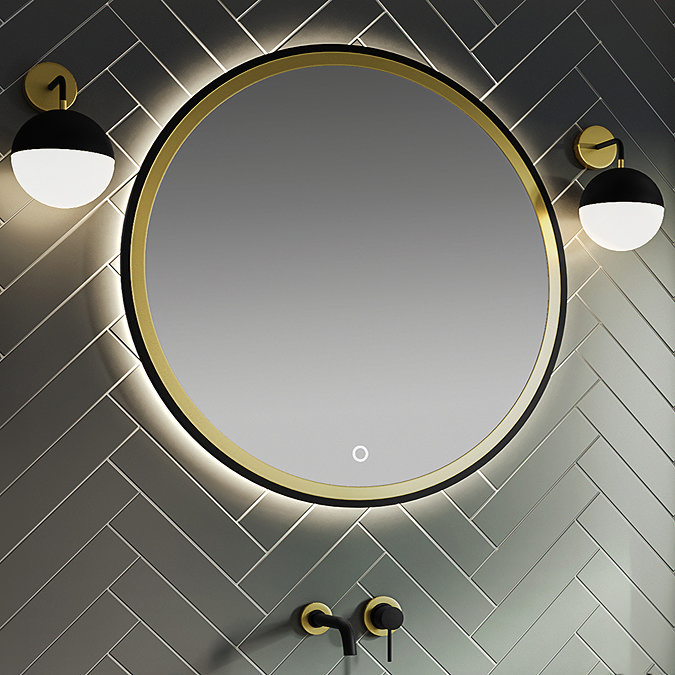 Bathroom with a large round LED-backlit mirror featuring a brass frame, paired with black and brass wall-mounted taps, and herringbone tiled walls.