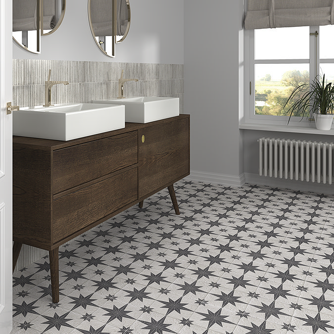 Star-patterned floor tiles in a modern bathroom with a dark wooden vanity, double sinks, and large windows providing natural light.