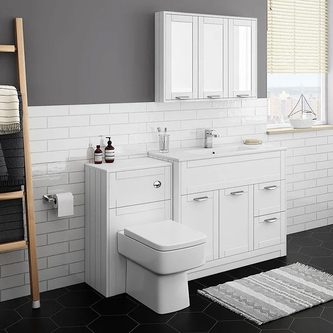 Modern white bathroom with fitted cabinets, toilet, and black hexagonal floor tiles