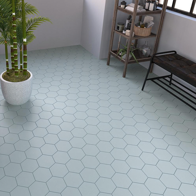 Light grey hexagon floor tiles in a modern bathroom with a potted plant, open shelving, and a black bench for a minimalist look.