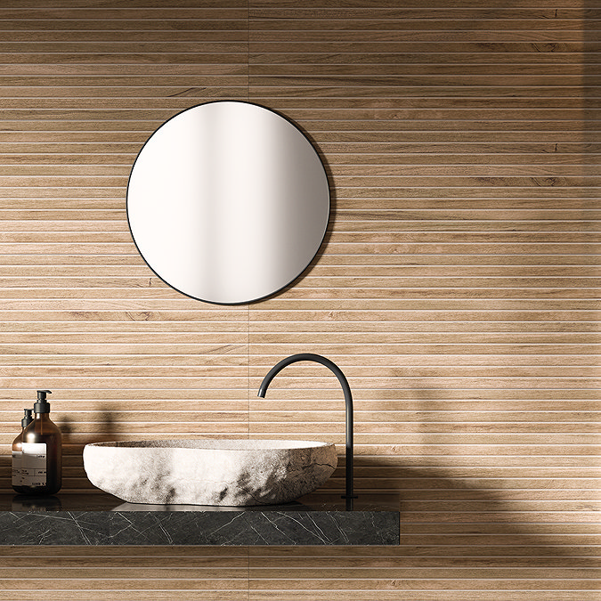 Modern bathroom featuring light wood-effect wall tiles, round mirror, and stone basin on a black marble countertop with a sleek black tap.