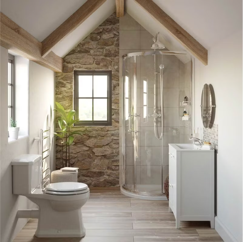 Country-style bathroom with rustic stone walls, exposed wooden beams, and a modern corner shower. The design features a white vanity unit and traditional toilet, blending natural textures with cosy charm.