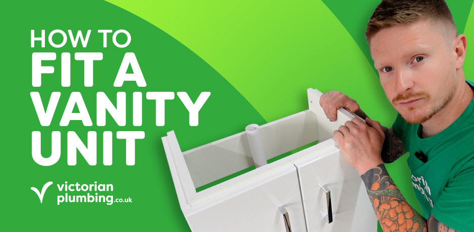 Plumber holding white bathroom vanity unit during DIY ‘How to Fit a Vanity Unit’ video by Victorian Plumbing