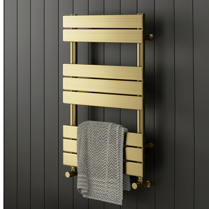 Gold towel radiator mounted on dark panelled bathroom wall with grey patterned towel