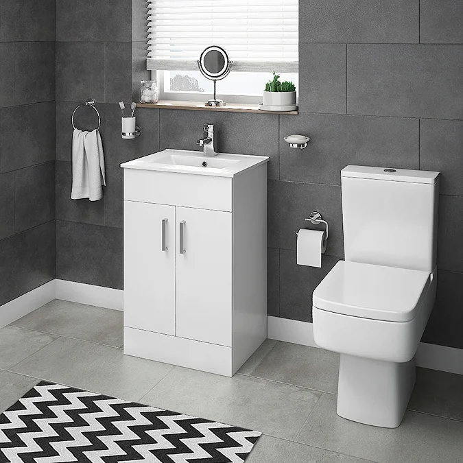 Modern bathroom with Toreno white gloss vanity unit and close-coupled toilet, set against dark grey tiles for a high-contrast, contemporary look