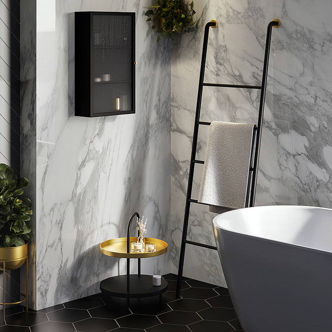Modern bathroom with black ladder rack leaning against marble wall holding a folded towel
