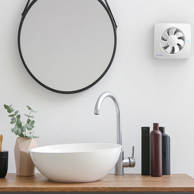 White bathroom extractor fan installed near a round mirror and modern basin, designed to keep the bathroom fresh and moisture-free.