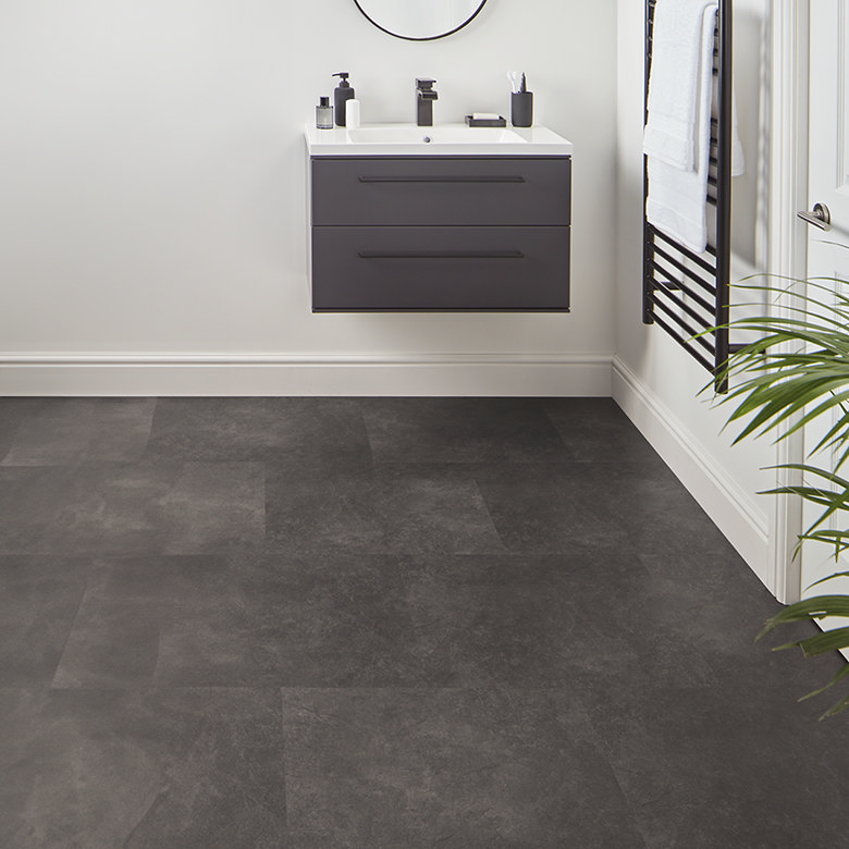 Modern bathroom with dark tiled floor and wall mounted vanity unit