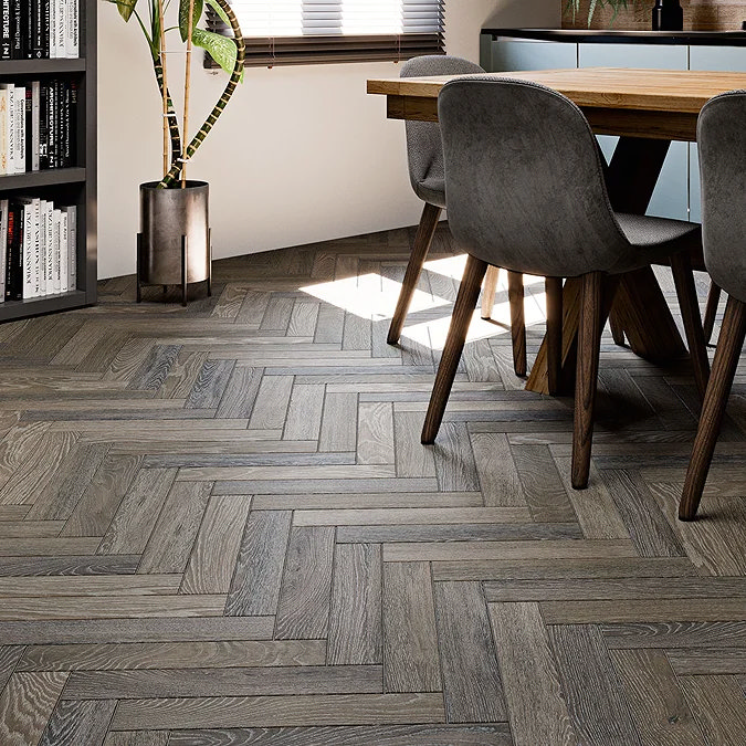 "Herringbone wood-effect flooring in a modern dining area with grey chairs and wooden table