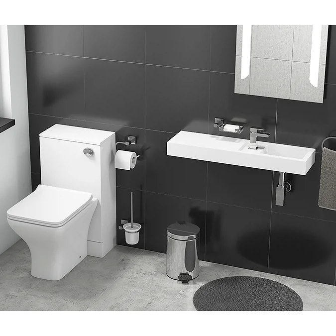 Long slim wall-mounted cloakroom basin with chrome tap beside close-coupled toilet in a modern black tiled bathroom.