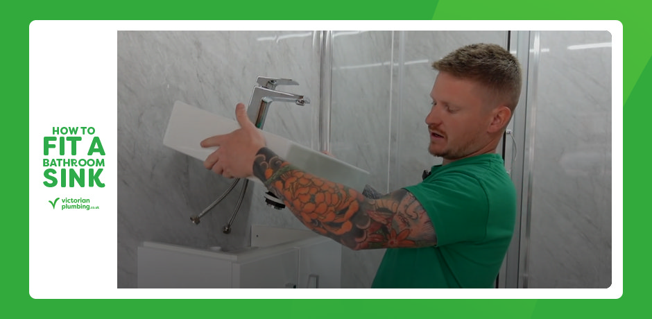 Plumber positioning a bathroom sink with pre-fitted tap onto a vanity unit