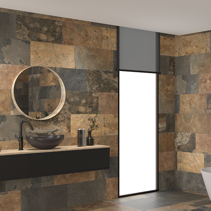 Modern bathroom with bold, earthy stone tiles on walls and floors, featuring a round mirror, matte black basin tap, and a black countertop vanity.