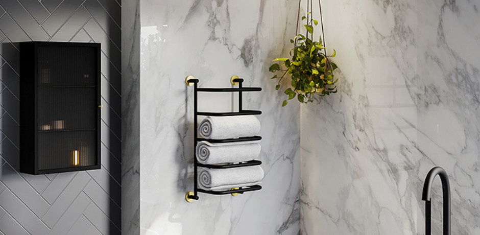 Modern bathroom with black towel rail holding rolled white towels against marble wall