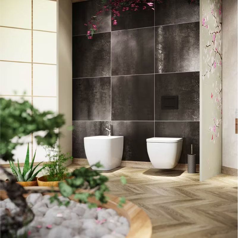 Japandi bathroom featuring a sleek wall-hung toilet and bidet against dark textured tiles. The natural wood herringbone floor and minimalist decor, with touches of greenery, create a serene, spa-like atmosphere.