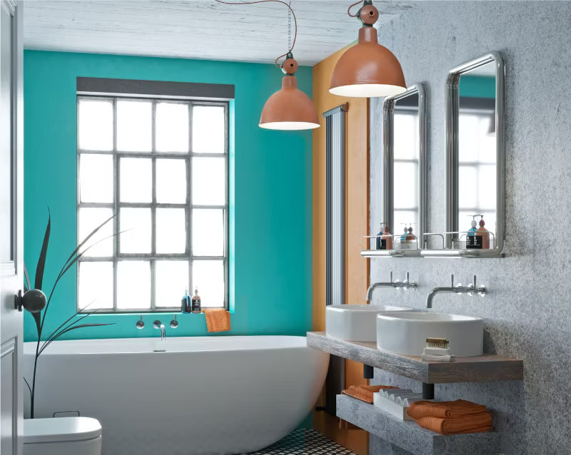 Bright bathroom with complementary orange and teal colour scheme, featuring a freestanding tub, double sinks, and industrial-style pendant lights, showcasing a bold, modern design using the colour wheel.