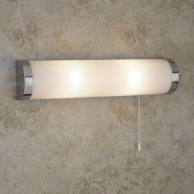Sleek chrome and frosted glass bathroom wall light with pull cord switch, offering soft, diffused illumination for modern interiors.