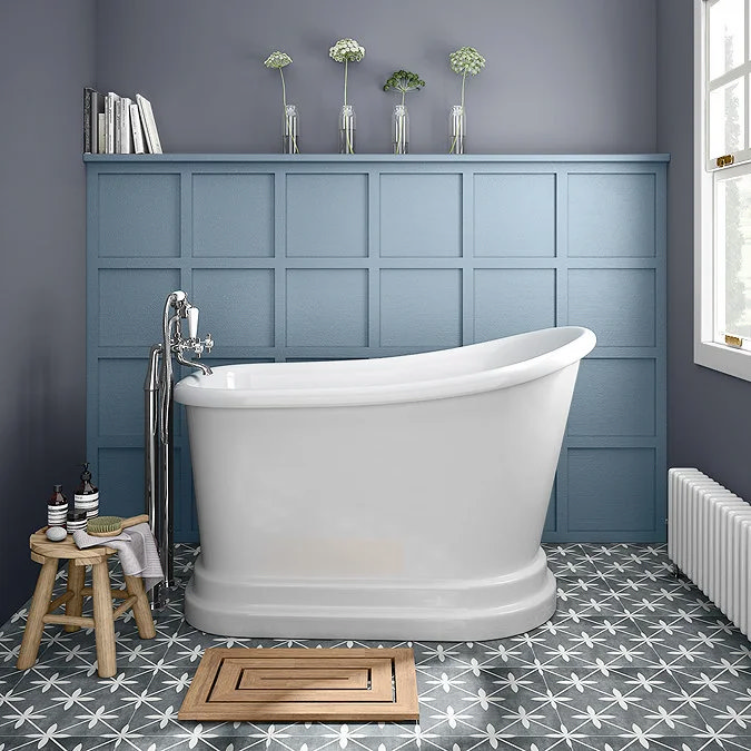 Freestanding white slipper bath with chrome taps, set against a blue panelled feature wall and patterned grey floor tiles, creating a classic yet contemporary bathroom design.