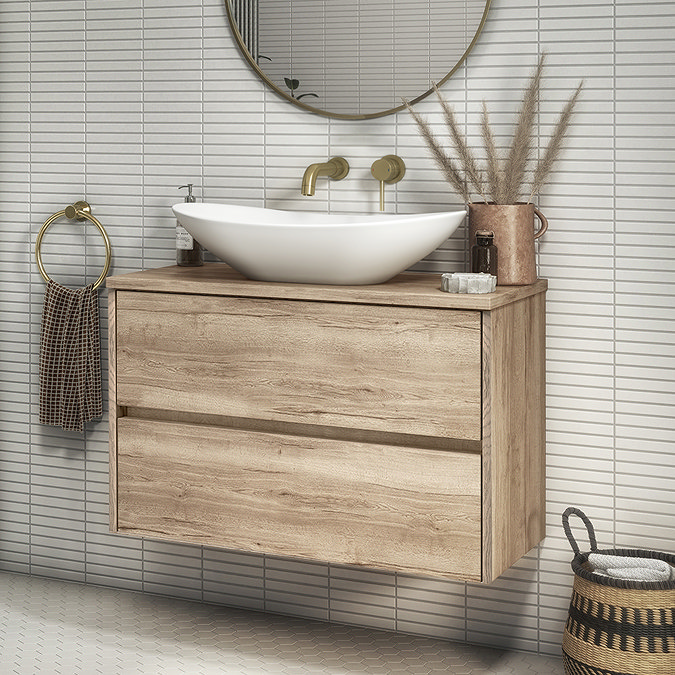 Rustic bathroom with wooden vanity, round mirror, and gold fixtures