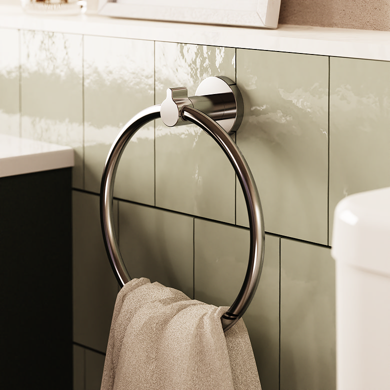 Wall-mounted chrome towel ring holding a hand towel against green bathroom tiles