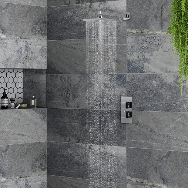 Chrome shower with dark grey stone effect tiles and hanging plant