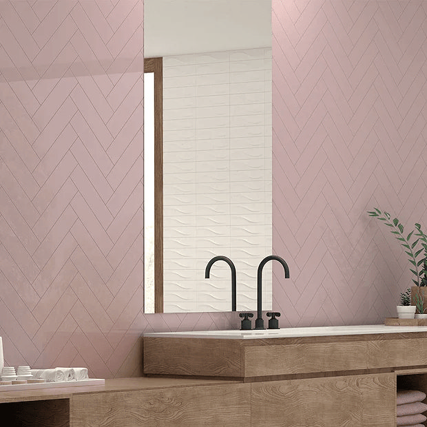 Pink herringbone tiles with oak countertop and black tap