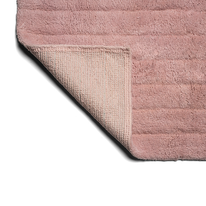 The bottom corner of the Croydex Pink Arched Bath Mat flipped up, showing the anti-slip feature on the underside.