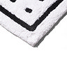 Bottom corner of the Croydex White and Black Squares Bath Mat, pictured on a white background.