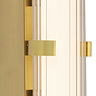 Close‑up of the gold clamp wall light showing the ribbed opal glass tube softly glowing in gold clamp.