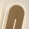 Close‑up of the satin‑brass wall light showing the glowing vertical slit and the dotted clear acrylic border illuminated around the edges.