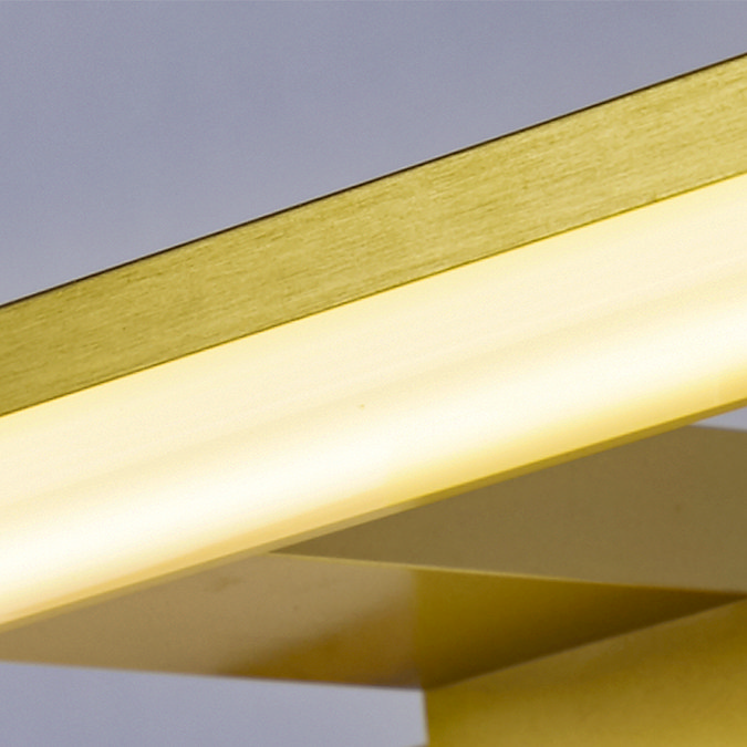 Close‑up of the glowing frosted diffuser and matt gold frame of the slim horizontal mirror light.