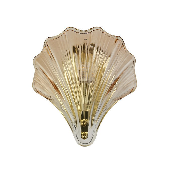 A scallop‑shaped wall light with ribbed amber glass and a satin brass fitting, shown switched off.