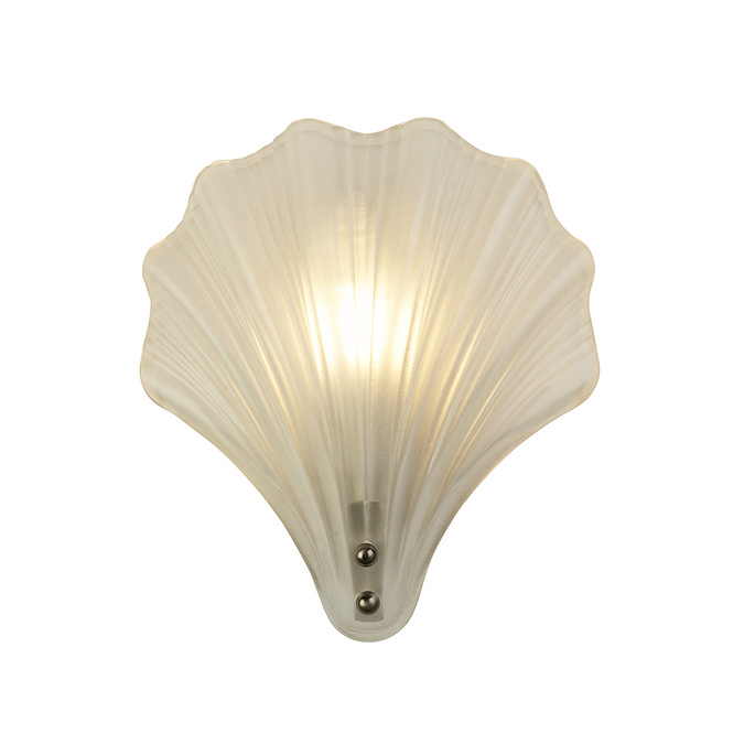 A scallop‑shaped frosted glass wall light with a satin silver fitting, shown illuminated to create a golden glow through the ribbed glass.