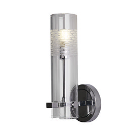 A chrome bathroom wall light with a cylindrical clear glass shade featuring a frosted etched pattern near the top, shown illuminated.