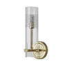 A satin brass bathroom wall light with a clear cylindrical glass shade and an etched frosted pattern near the top, shown switched off.