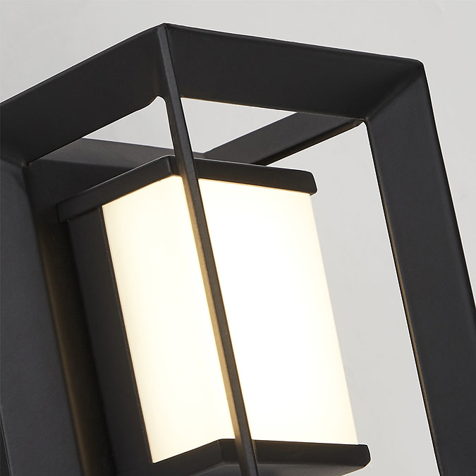 Close‑up of the black square wall light showing the opal acrylic diffuser inside the open metal frame.