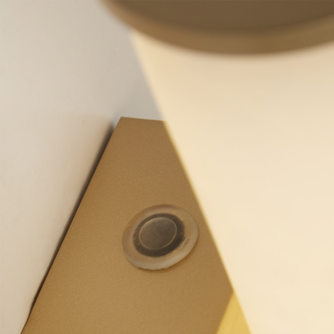 Close‑up of the wall light showing the base of the marble‑effect cylinder and a small circular mounting detail on the backplate.