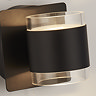 Close‑up of the matt black up‑and‑down wall light showing the clear acrylic cylinder that diffuses light above and below.