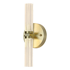 This image shows a modern wall‑mounted light fixture. It has a cylindrical light bar running vertically, with textured clear acrylic that diffuses the light. The cylinder is attached at the centre to a round satin‑brass metal base, giving it a sleek and elegant appearance. The fixture casts light both upward and downward and has a warm, contemporary look.