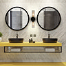 A matt black up‑and‑down wall light with two ribbed glass shades mounted between two round mirrors above a modern double‑basin vanity in a marble‑tiled bathroom.