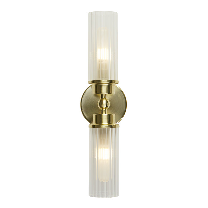 A satin brass up‑and‑down wall light with two clear ribbed glass shades, each glowing softly to show the light is switched on.