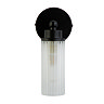 A matt black wall light with a clear ribbed glass cylinder and a round black wall plate, shown switched off.