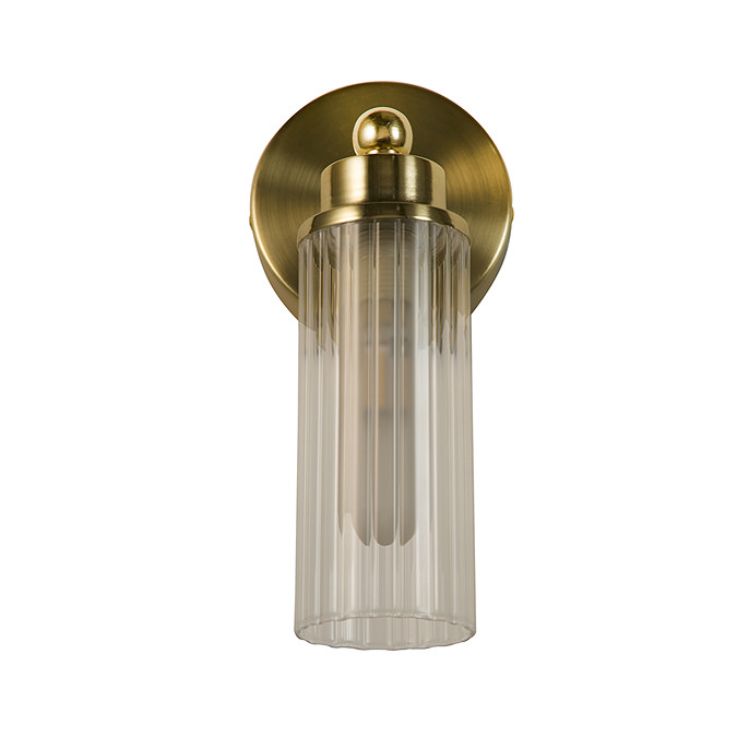 A satin brass wall light with a clear ribbed glass cylinder and a round brass wall plate, shown switched off.