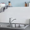 Grohe Swift low spout kitchen mixer tap in chrome installed in a stainless steel kitchen sink.